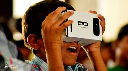 Young boy looks joyously through a virtual reality cardboard box 