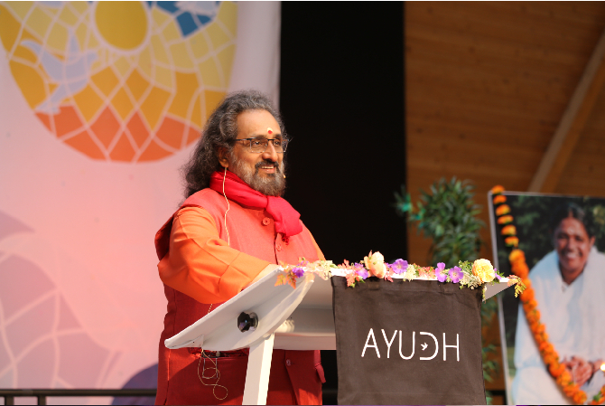 Swami Amritaswarupananda Puri at a podium, addressing the crowd. 