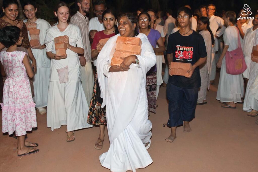 Amma with volunteers carrying bricks