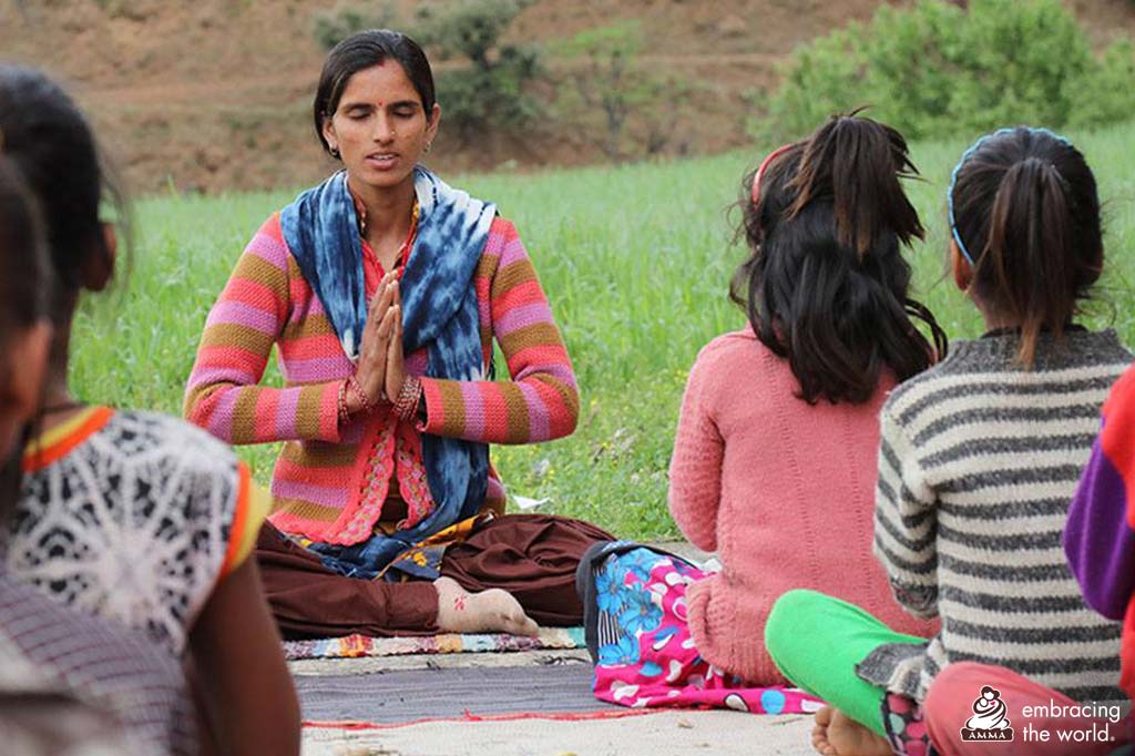 A woman leads an outdoor yoga class