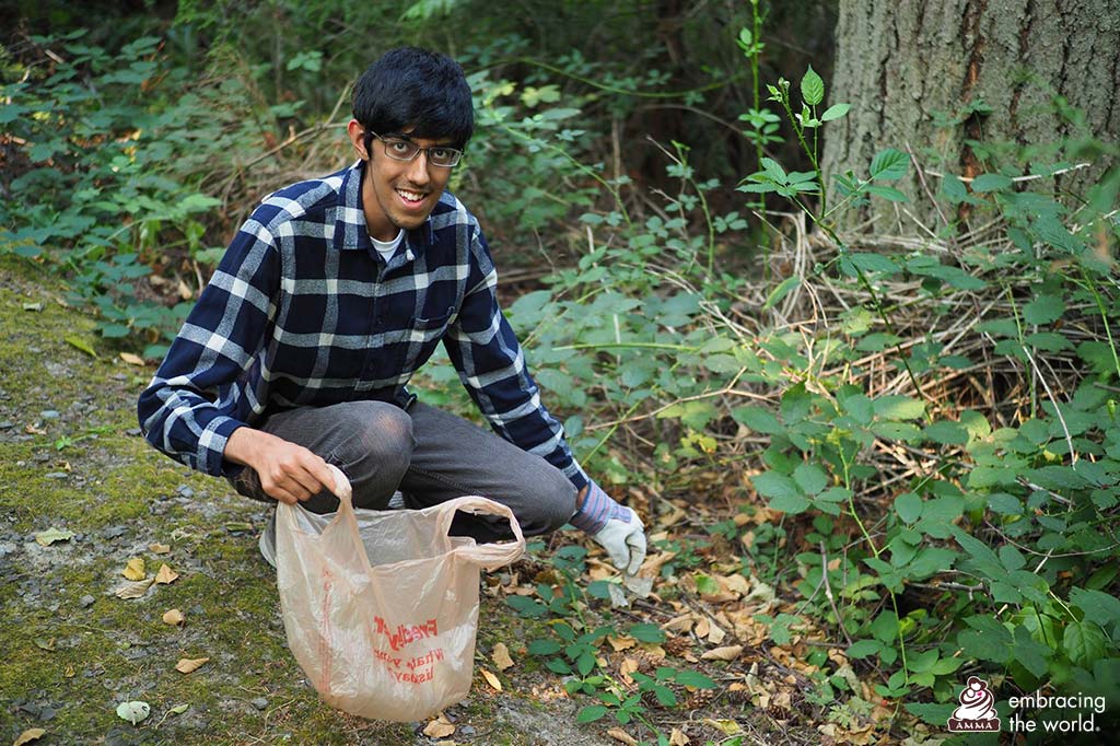 A man picks up trash in the forest