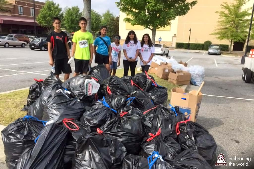 Students stand next to a mountain of full trash bags