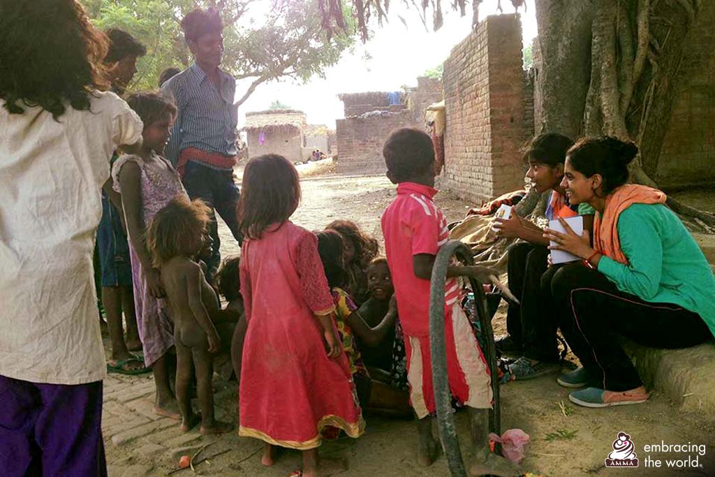 A group of children from a village speak with college students