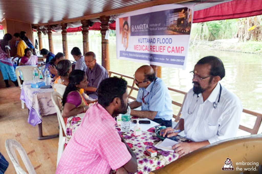 A row of doctors sit on a boat and meet with patients