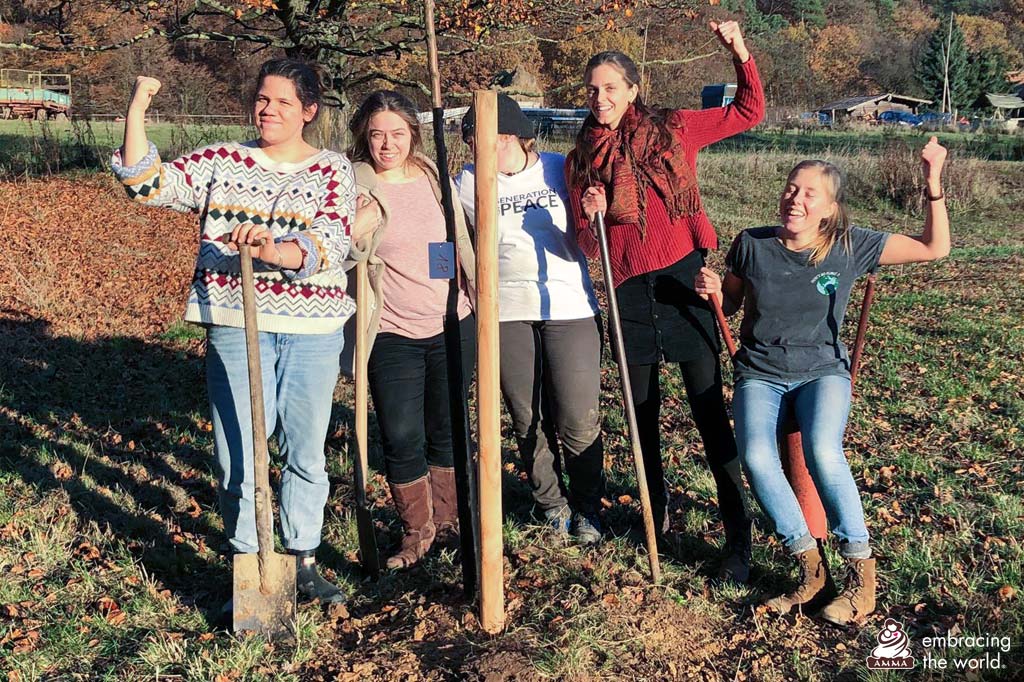 Five volunteers celebrate after planting a tree