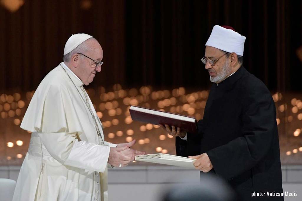 Pope Francis and Grand Imam Ahmed el-Tayeb hand each other documents