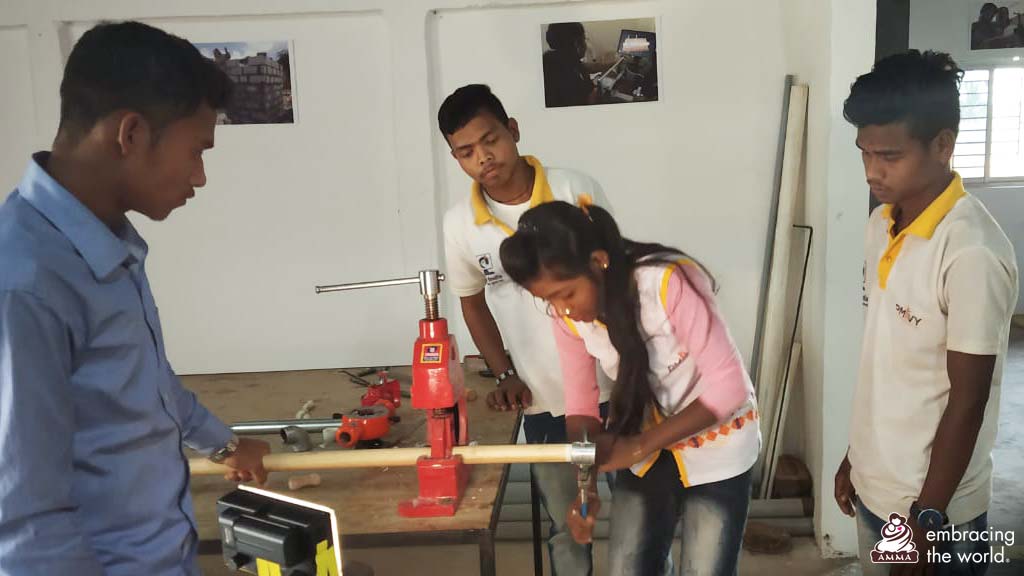Young girl practices using plumbing equipment. She is surrounded by three men 
