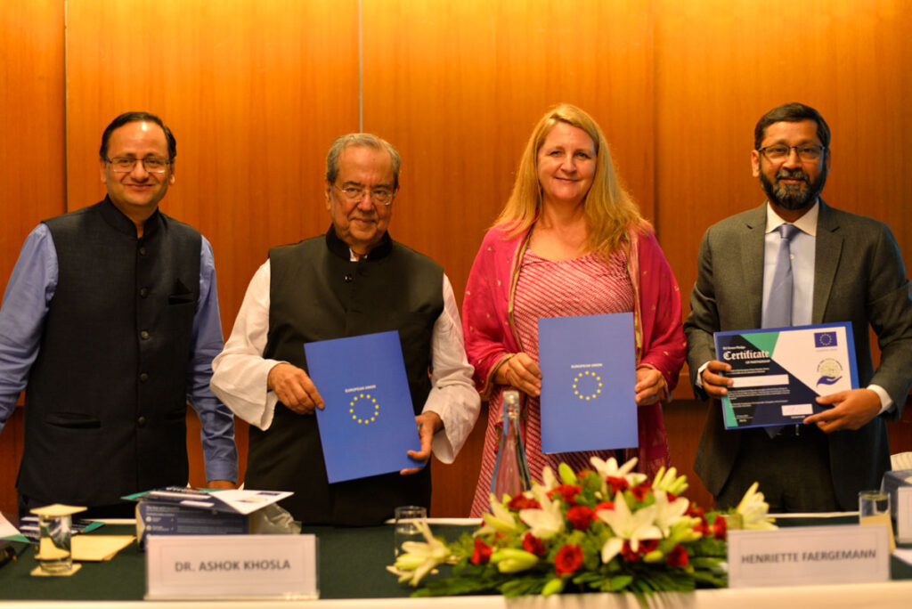 Four peope standing and holding copies of the pledge