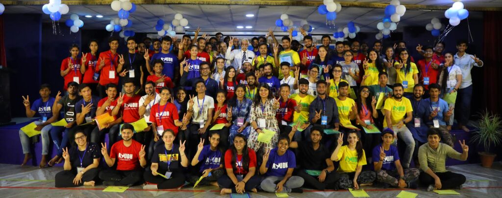 Group photo of the 90 plus youth participants in red, yellow, and blue AYUDH t-shirts.