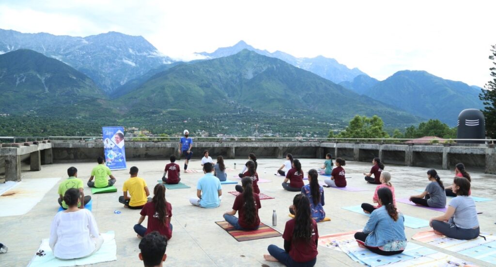 attendees seated in meditation facing mountains