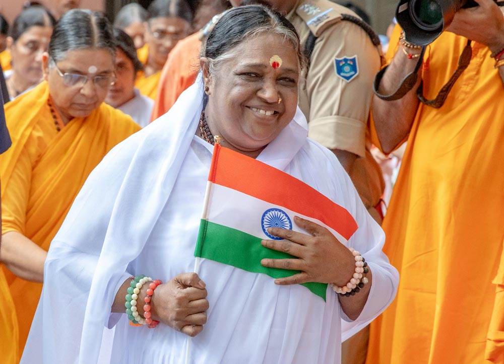 Amma holds a small flag close to her heart