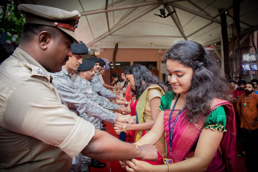 Ashram children tie bracelets around the police officers