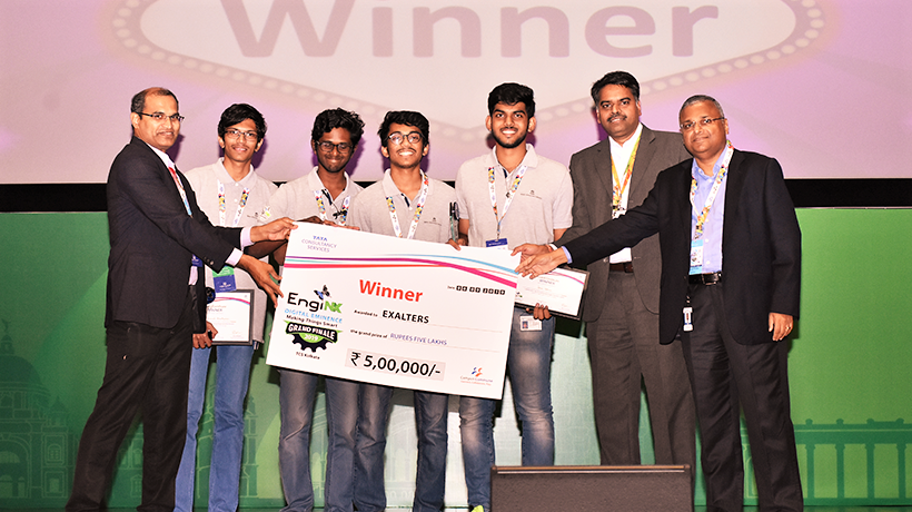 Our Amrita University team, with big smiles, holding up a large cheque with officials from the competition