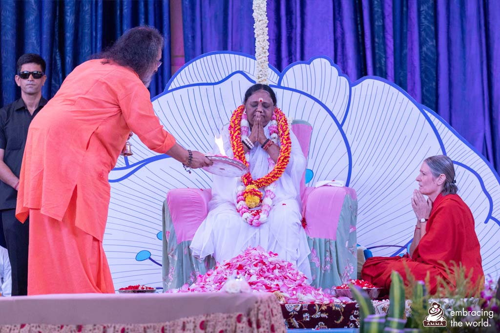 Amma holds her hands in prayer