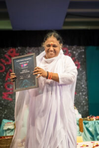 Amma holds up the award