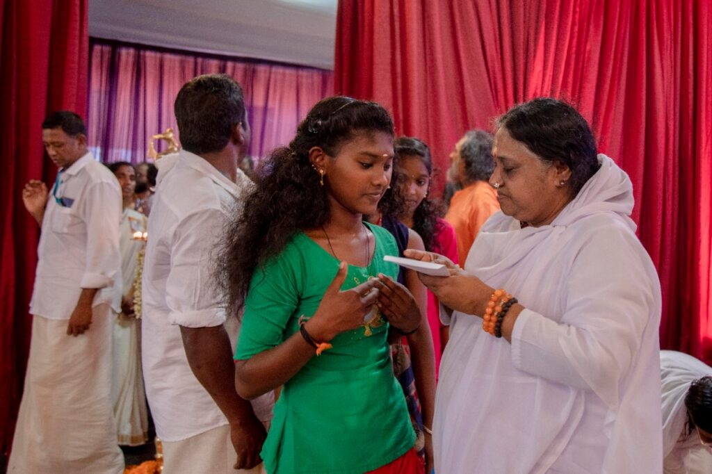 Amma hands over envelope to student