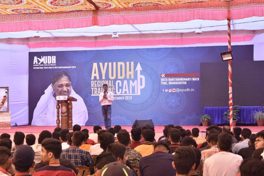 man standing on stage addressing the crowd