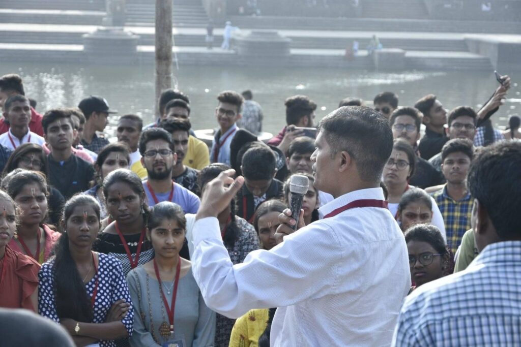 man facing a crowd talking