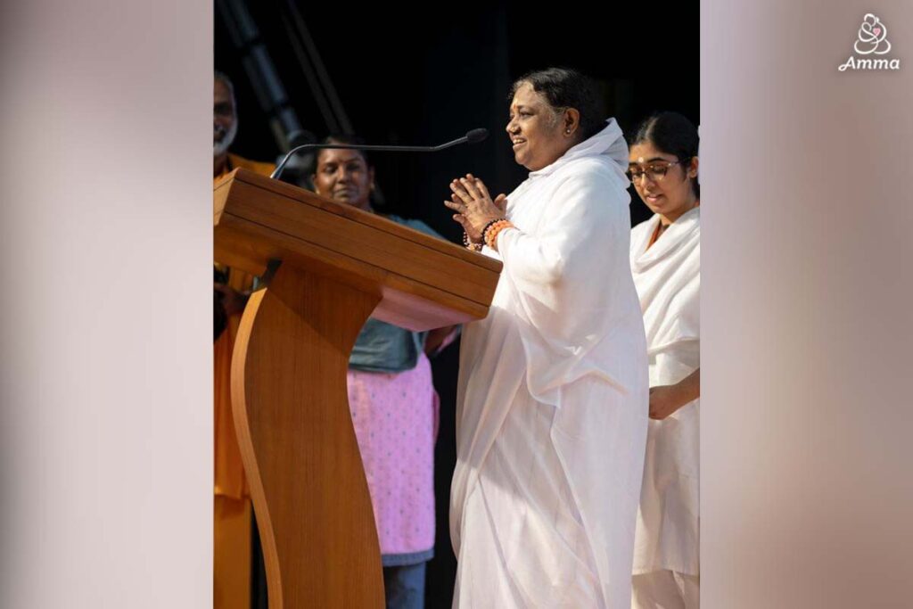 Amma speaks at a microphone
