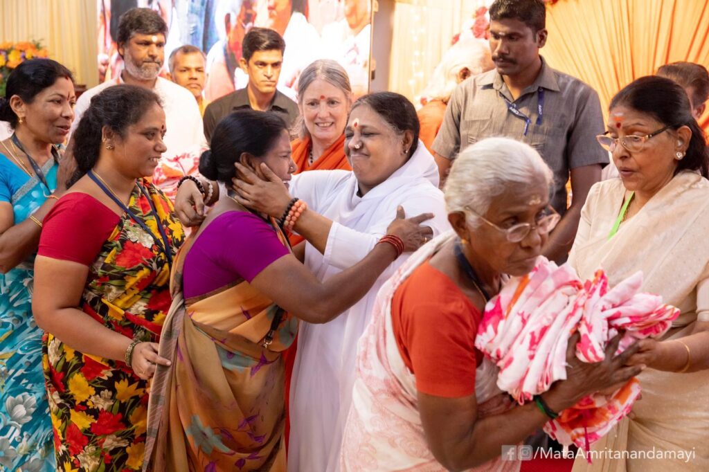 Amma embraces underprivilged women while distributing saris