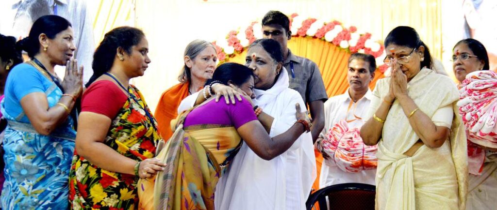 Amma embraces underprivilged women while distributing saris