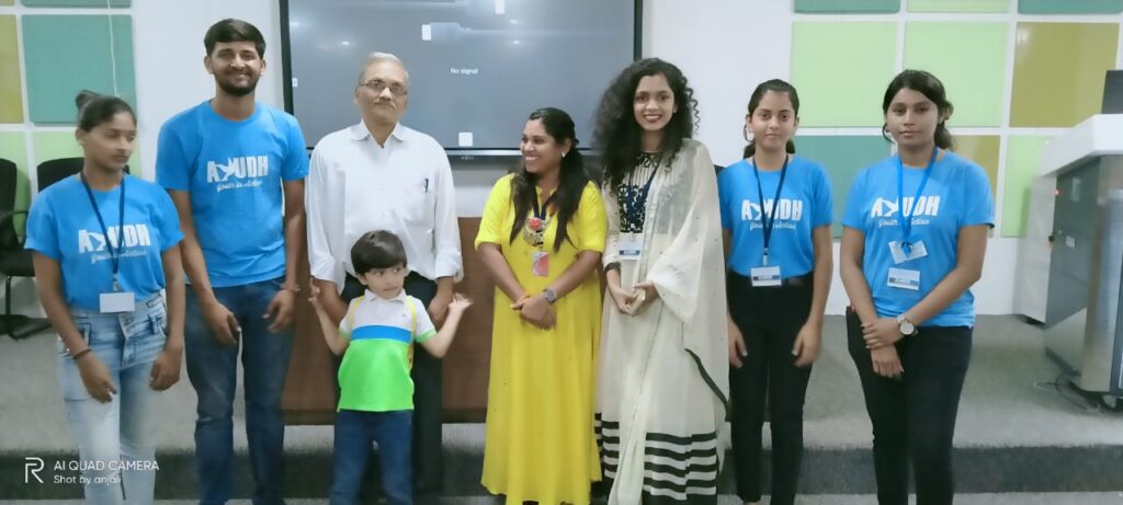 AYUDH members and administrators for the college, stand at the front of the classroom, smiling.