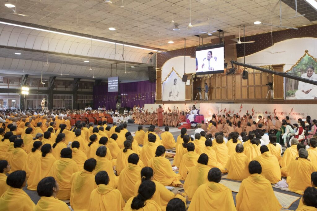 Newly ordained Brahmacharis and Brahmacharinis, seated in their new yellow robes. 