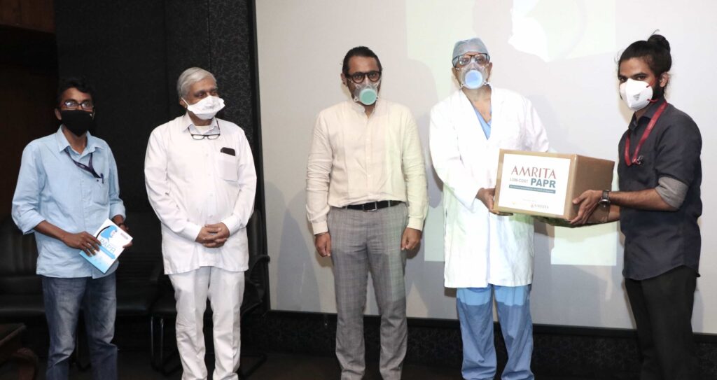 Doctors stand with PAPR in a box