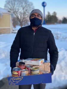 Volunteer stands with his hands full of goods