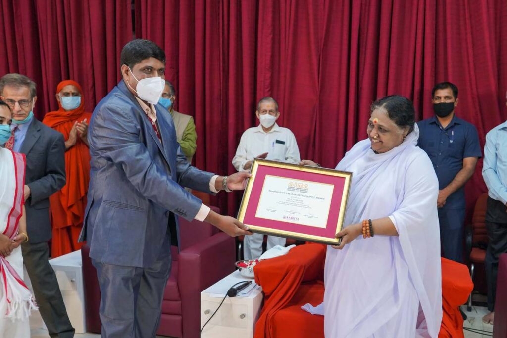 Amma hands over placcard to guest