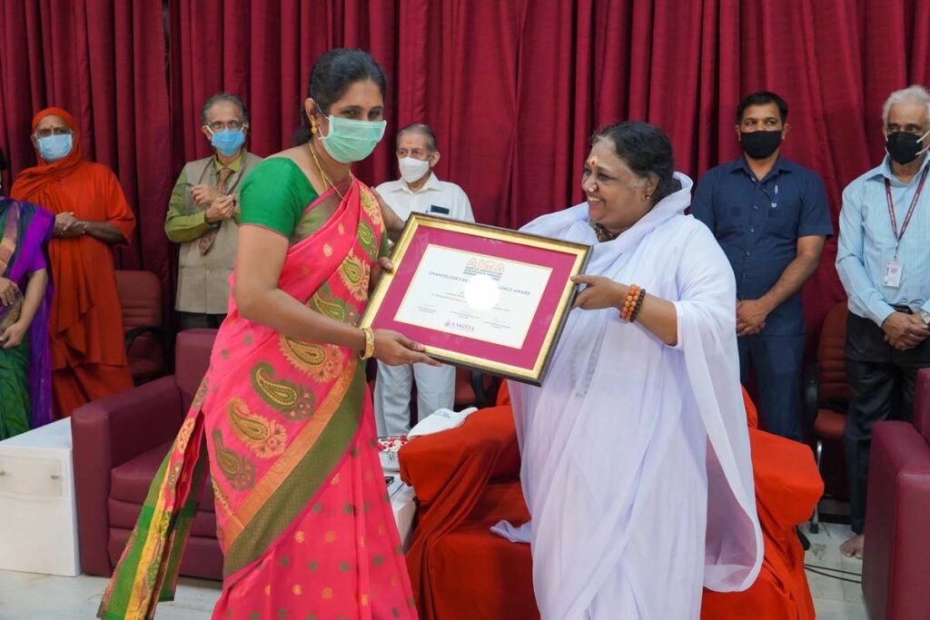 Amma hands over framed award
