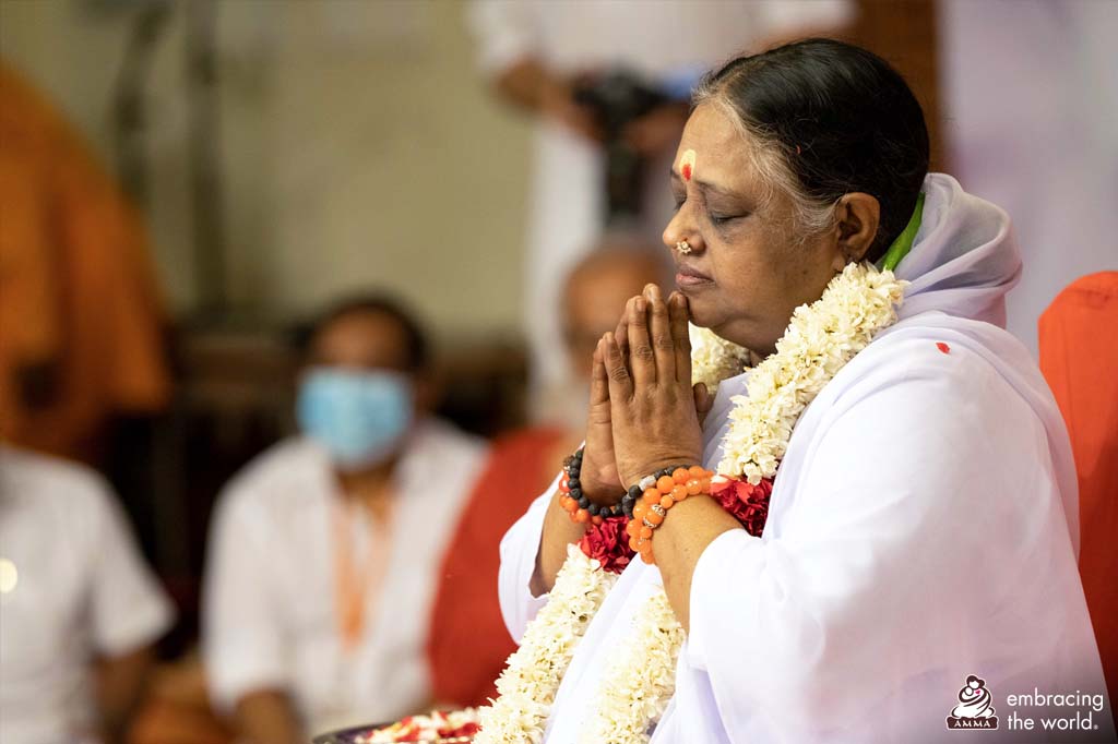 Amma holds her hands in prayer