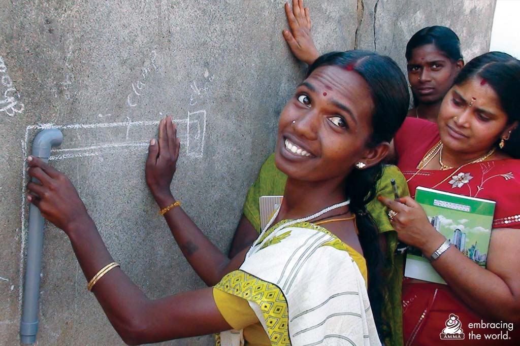 Women write on a backboard and turn to smile at the camera