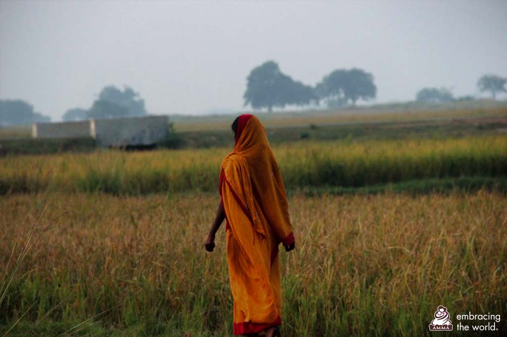 A woman stands alone in a field