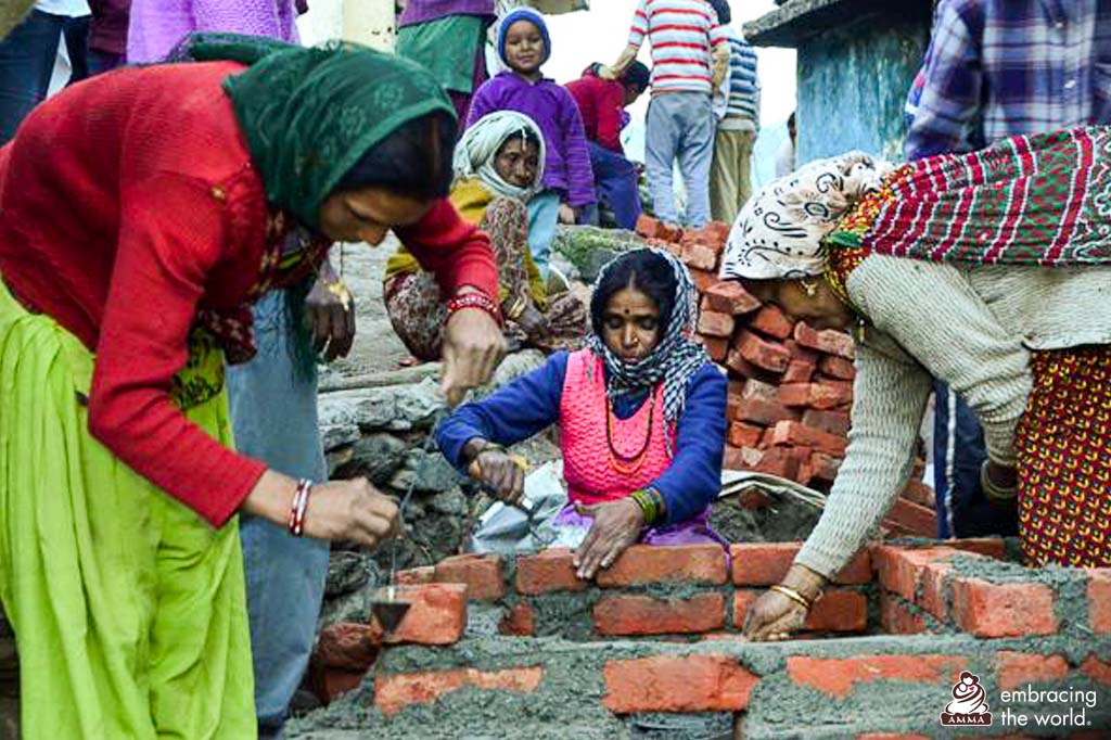 Women build a brick wall together