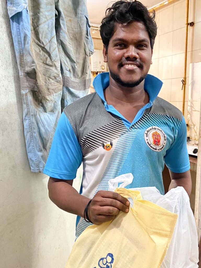 A happy worker holding two of the bags of donated items.