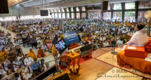 The hall is full and Amma watches those joining via zoom as well