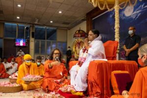 Swamiji offering flowers in front of Amma