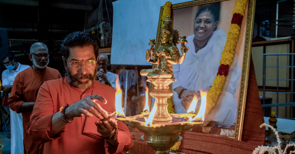 Swami lights a lamp as part of the ceremony