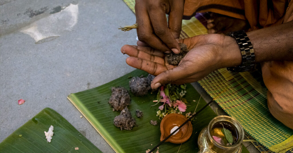 The hand of someone performing the puja