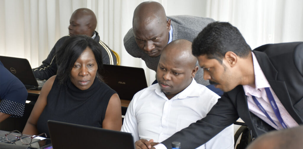 Trainers gather around a computer