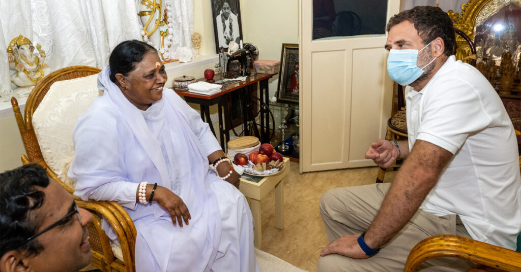 Amma sitting across from Mr. Gandhi as they talk