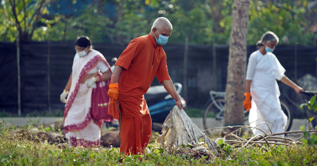 A Swami and two other people are picking up trash