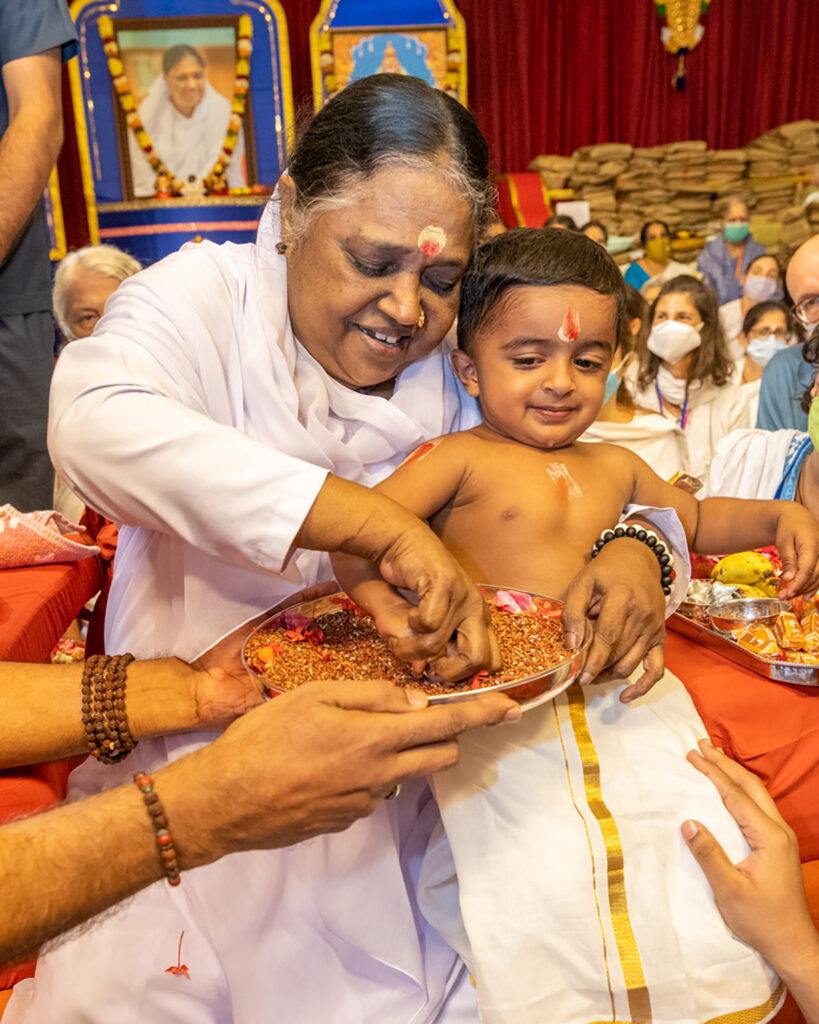 Amma teaches a baby boy to write