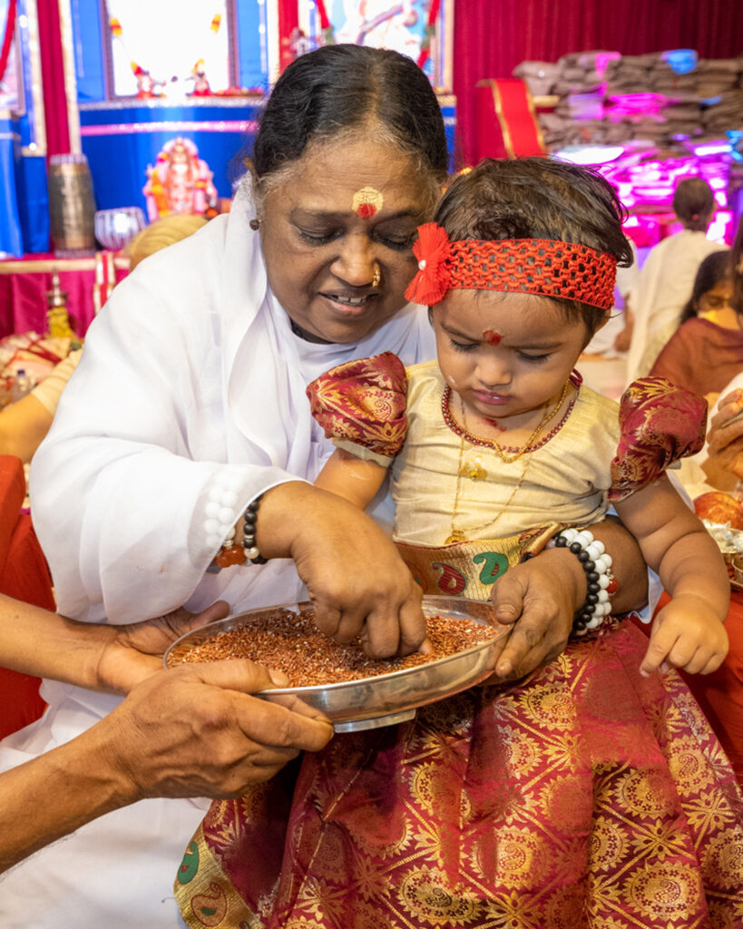 Amma teaches a baby girl to write