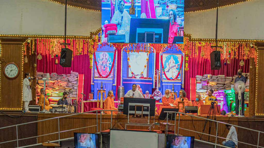 Amma sits on a decorated stage