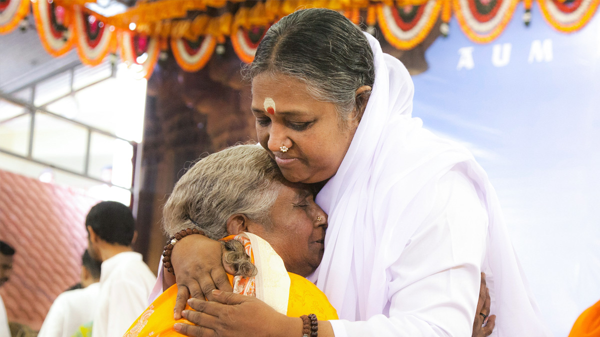 Amma embraces and elderly woman
