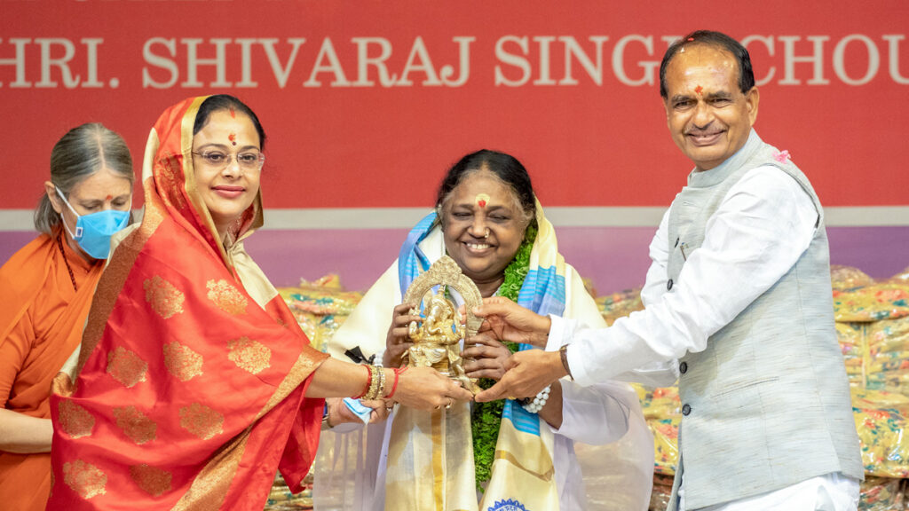 Minister and his wife place a shawl over Amma and give her a statue of Ganesh