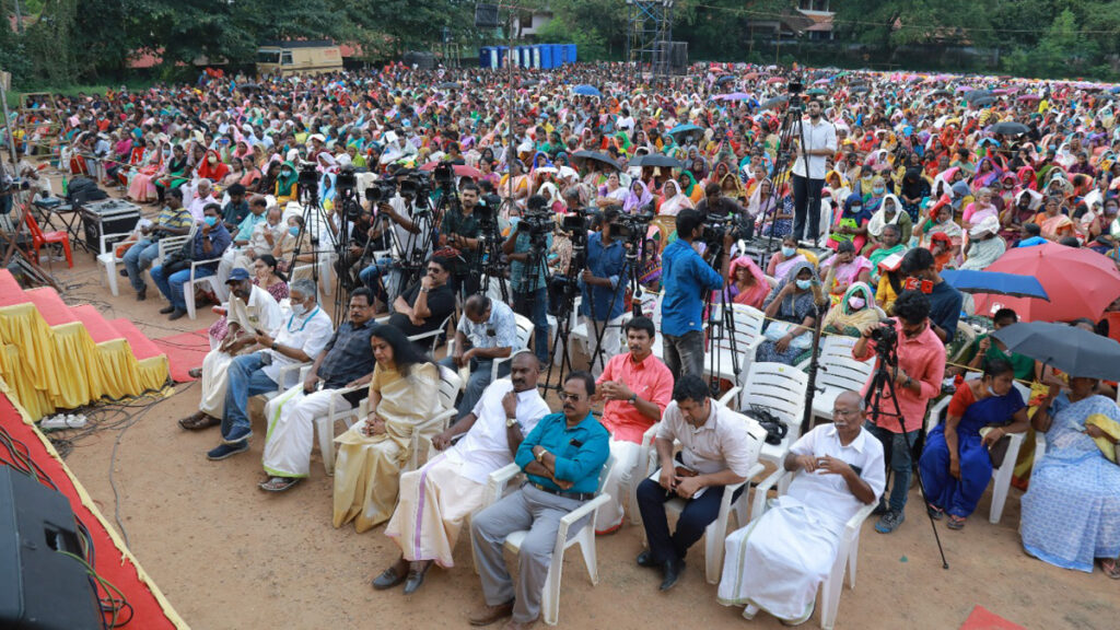 Huge crowd of people sit in an outdoor venue