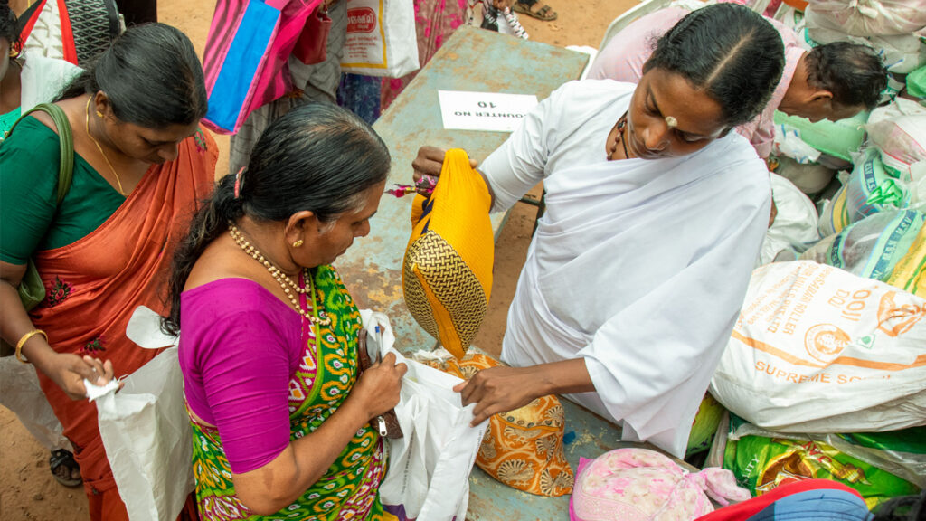 Amritapuri Ashram volunteer passes out food items